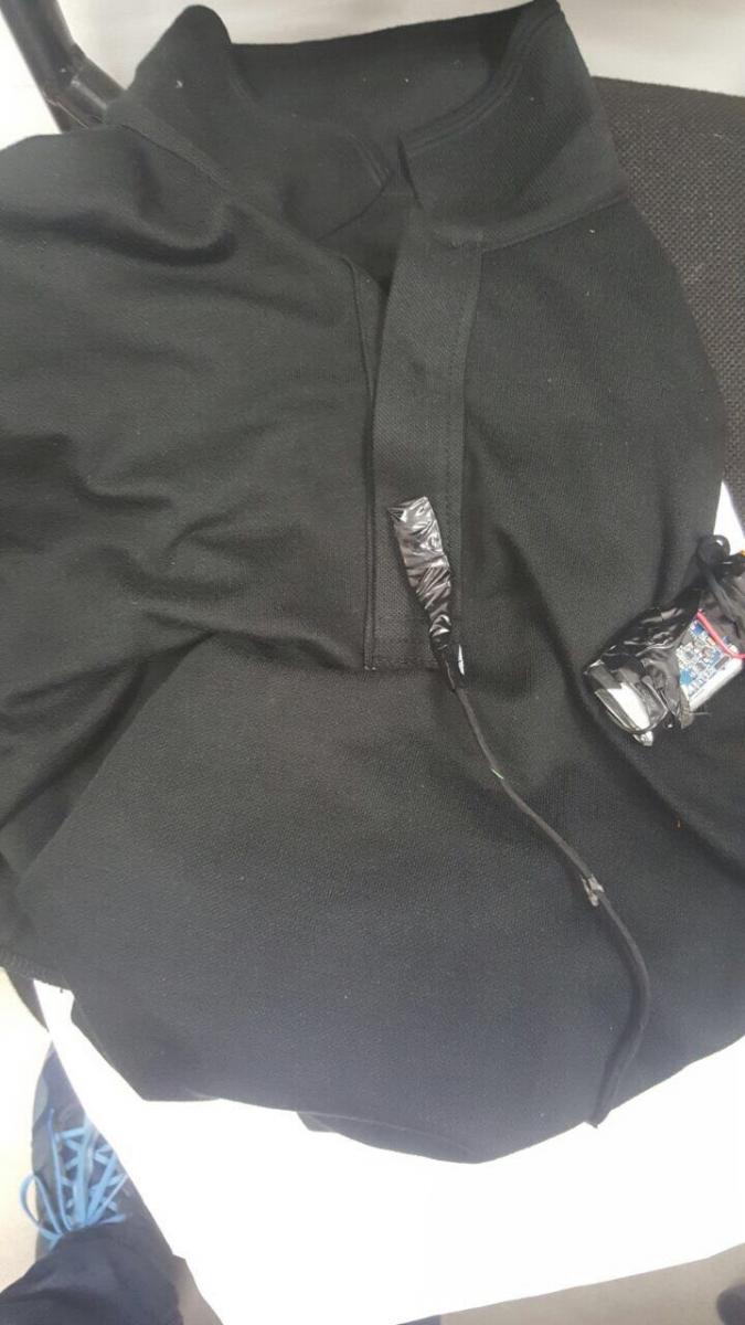 כך זה נראה: מצלמה זעירה הוסלקה בתוך חולצה (צילום: דוברות המשטרה)